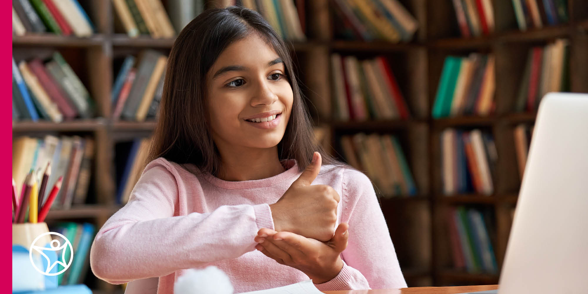 Young teen in a pink sweater giving a thumbs up