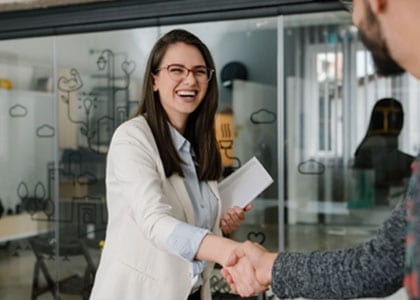 Career program student in suit shaking hands with a professional
